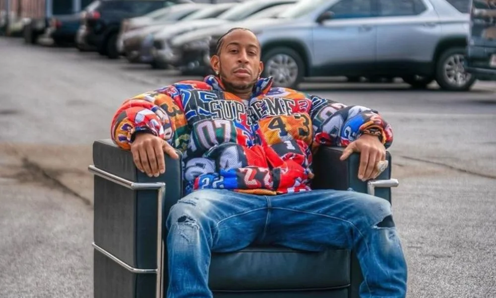 A person sits confidently in a large black chair on a street