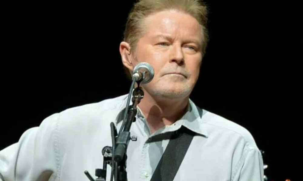 A man with short, light hair performs on stage