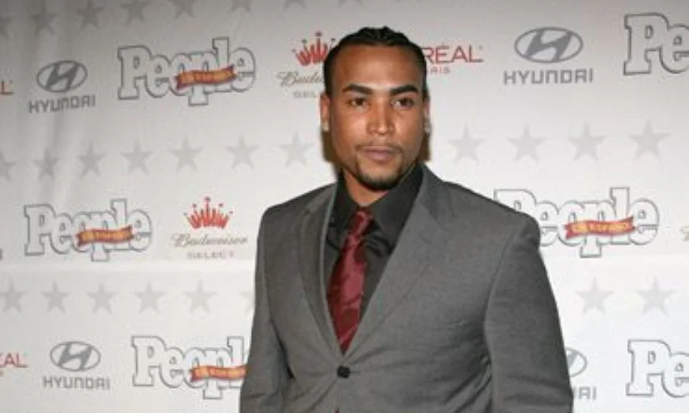 A man in a gray suit-don omar net worth