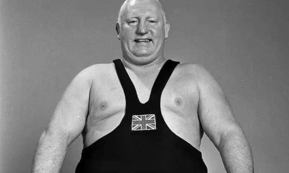 muscular man stands confidently in a wrestling singlet