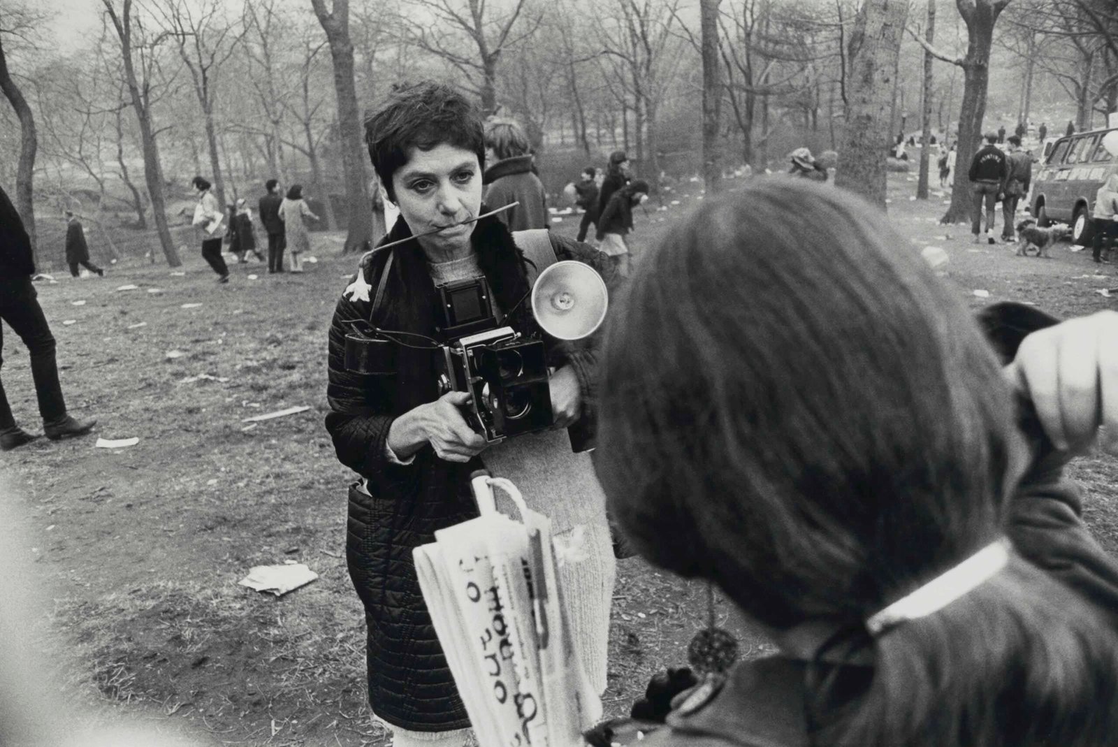 Diane Arbus holding a medium-format TLR camera in a park