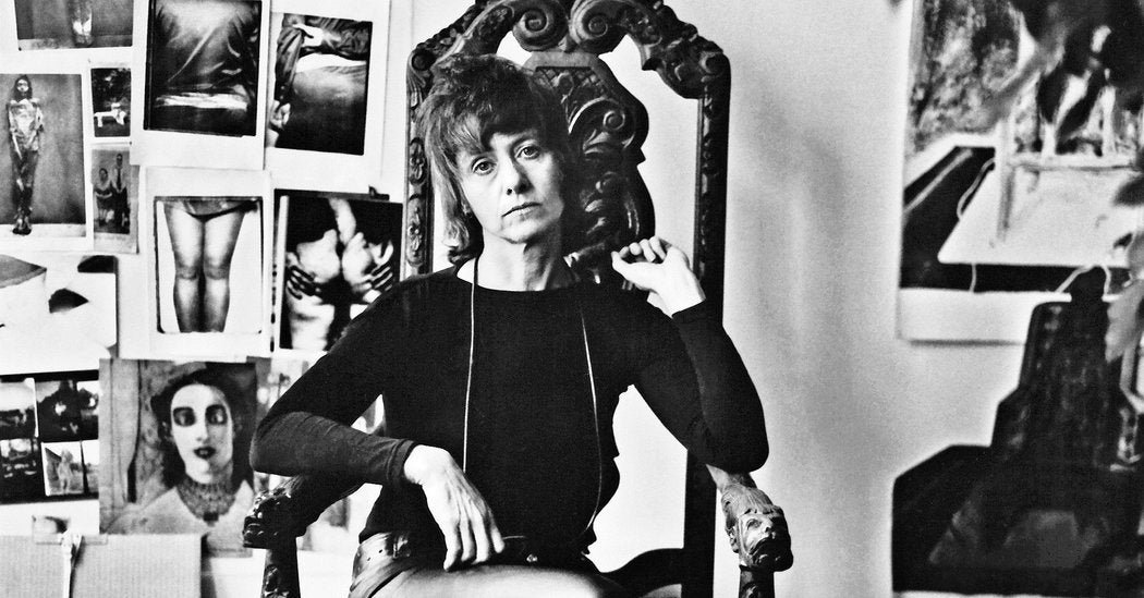 Diane Arbus sitting in a carved chair in her studio