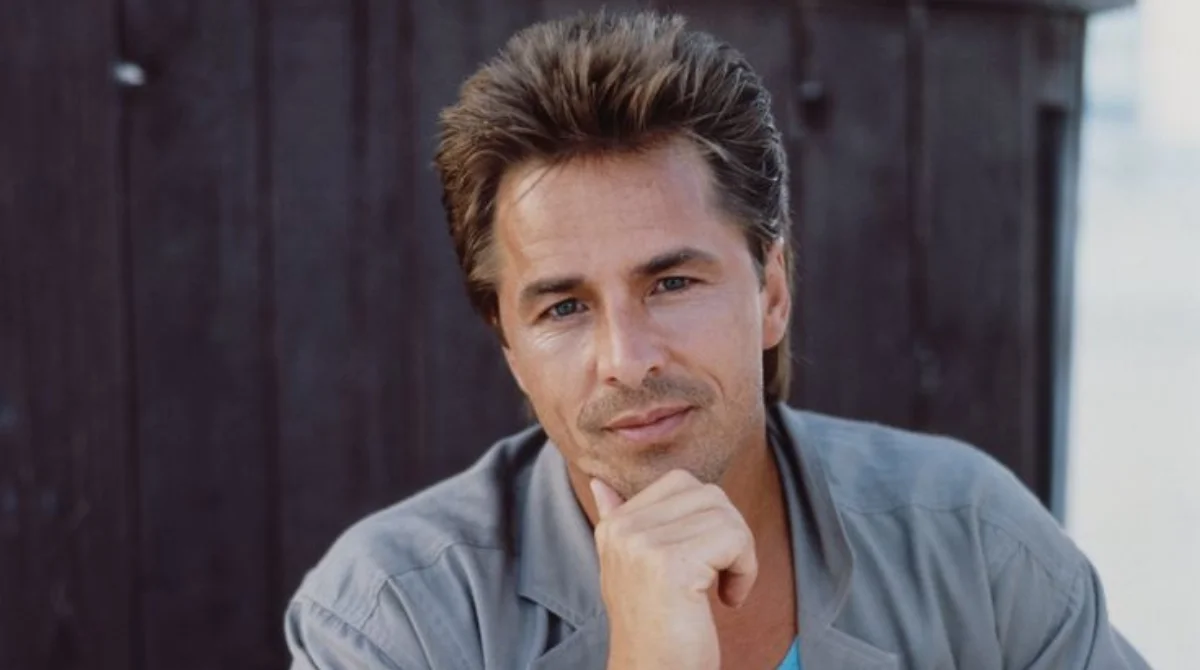 A man with short brown hair and a slight smile poses
