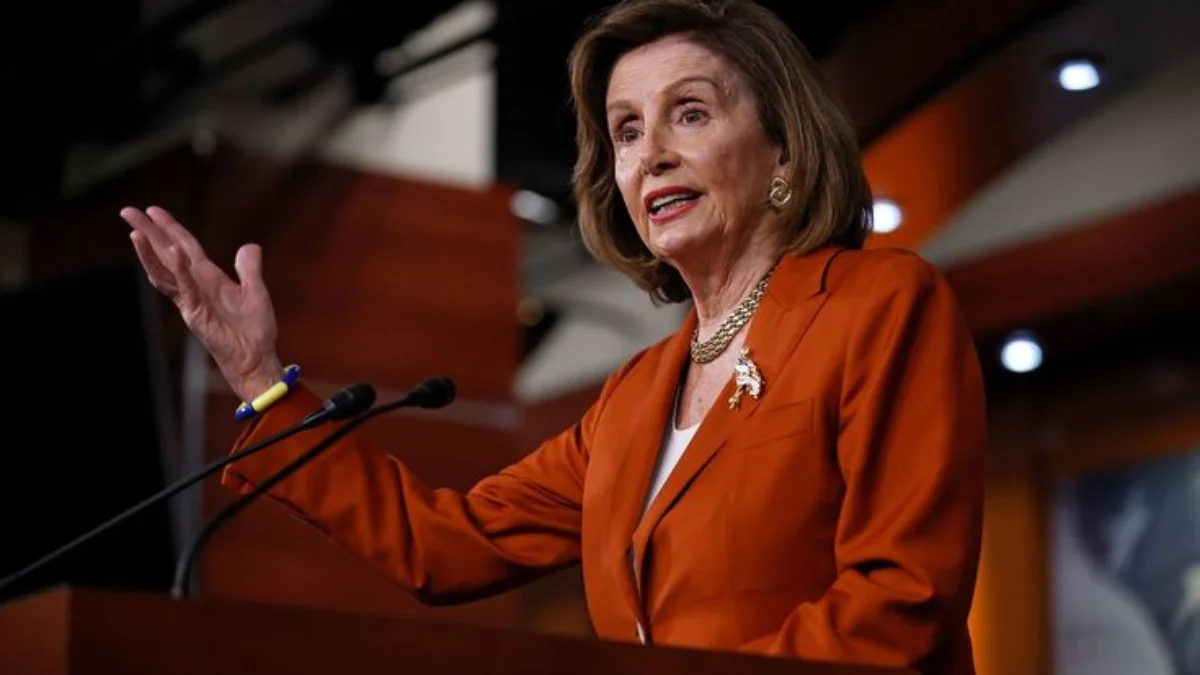 A woman in an orange blazer speaks