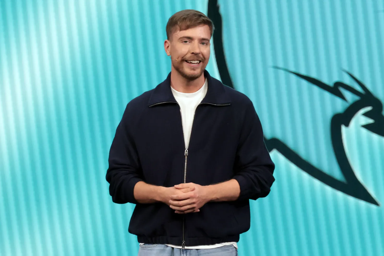 Jimmy Donaldson alongside contestants in matching blue tracksuits celebrating a five million dollar cash prize set on a reality show production tracked by marianoiduba.