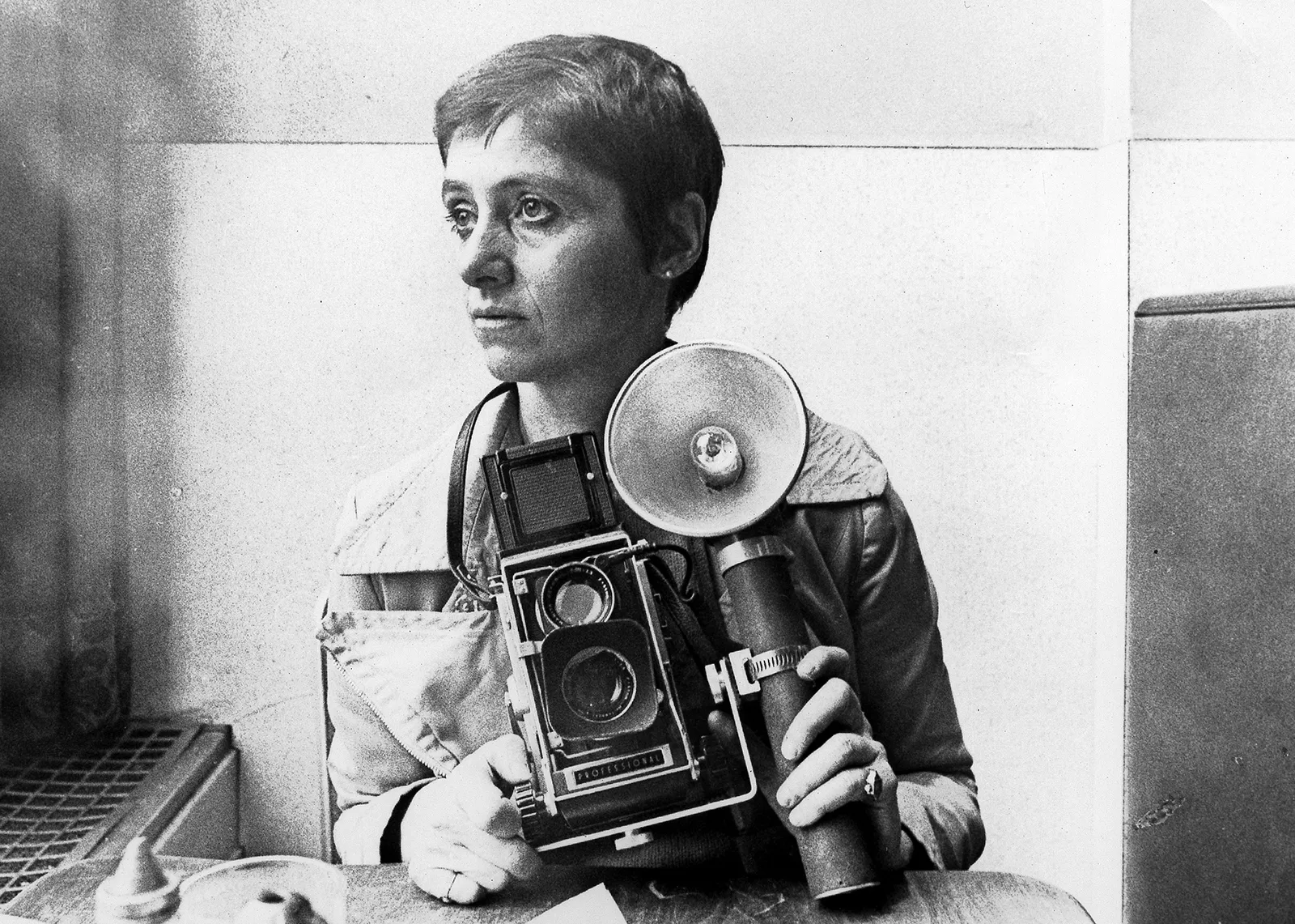 Diane Arbus holding a Mamiya medium-format camera and flash